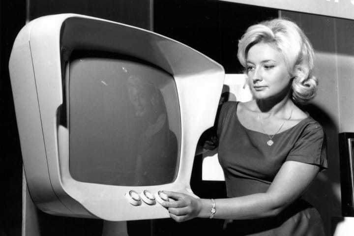 A woman is pictured operating a television